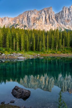 Italian alps. Silent morning on the lake of Carezza surrounded by pine forest and mountains.