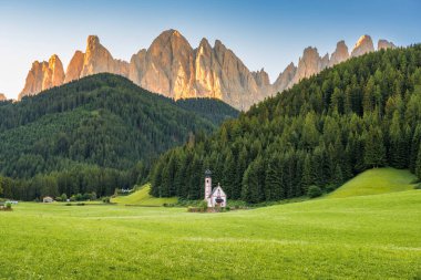 Gün batımında Santa Maddalena 'daki Ranui Şapeli' nde St. John 's ile Dolomitlerin Sahnesi. İtalya