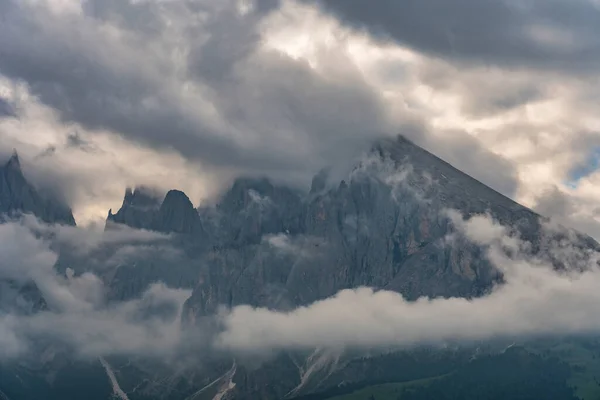 Close up of mountains hidden in fog at Sunrise of Alp De Suisi, Dolomites, Italy