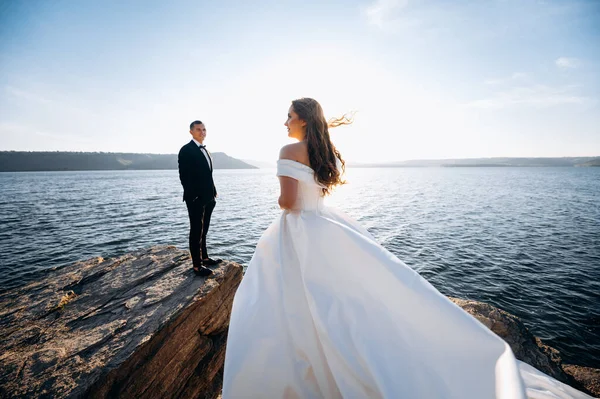Beautiful couple on the beach in wedding dress. Beautiful wedding couple looking at each other near ocean with perfect view