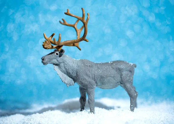 Miniature de Noël d'un cerf sur un fond bleu brillant enneigé. Concept créatif de nouvelle année — Photo