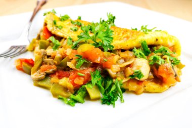 Mexican omelet with fresh vegetables set on a white plate.