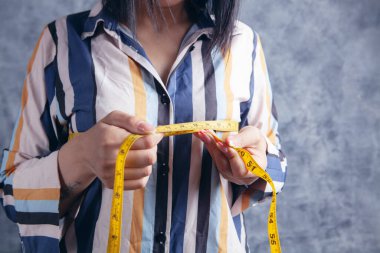 Genç kız göğüslerini ölçüyor.