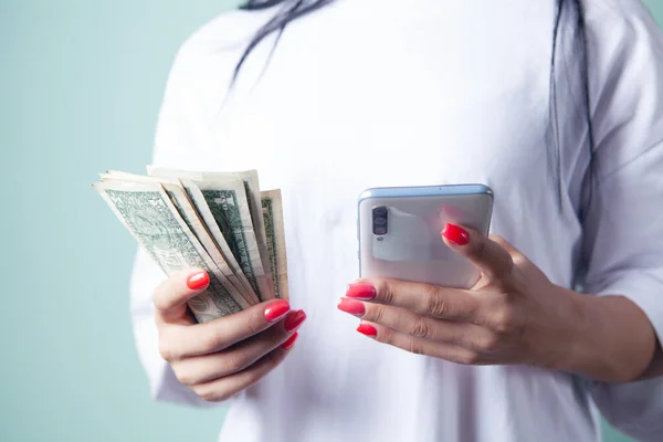 woman holding banknotes and phone