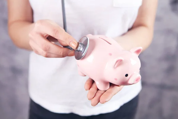 Young Woman Listens Piggy Bank Stethoscope — Stock Photo, Image