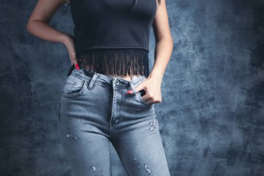 Kadın sütyen ve pantolon giymiş poz veriyor.