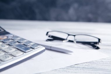 Hesap makinesi, kağıtlar, bardaklar ve kalemler masaya. masaüstü konsepti