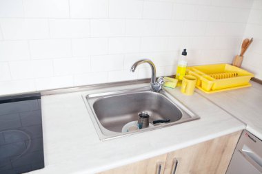 Mutfakta lavabo ve çatal bıçaklarla.