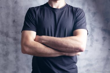 Adam kollarını kavuşturmuş duruyor.