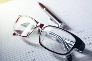 optik gözlük ve kağıt üzerinde kalem