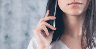Bir kadın ev telefonundaki bir numarayı çevirir.