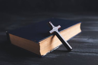  Kitap ve haç masanın üzerinde.