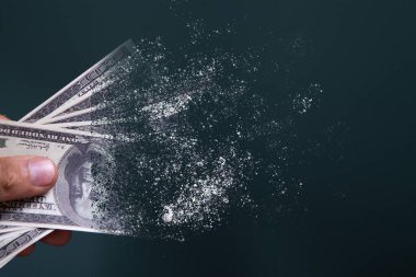 Dolar banknotları mavi arka planda kaybolur.