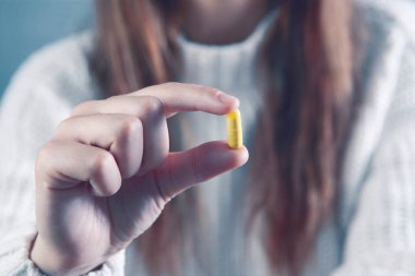 bir kapsül tutan genç kadın