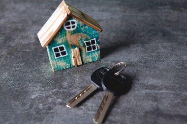 Küçük ev ve anahtarlar masanın üstünde.