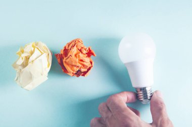 Buruşmuş kağıtlar ve masada bir ampul.