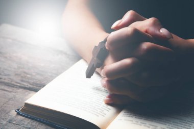 Kadın haç tutarak dua ediyor