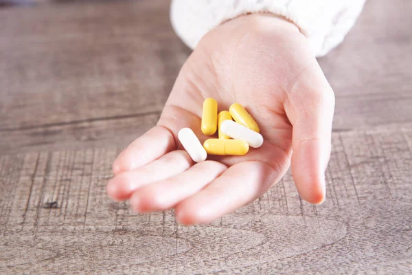Elinde kapsüller tutan genç bir kadın.