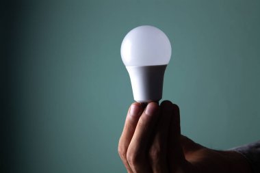 Elinde ampul tutan bir iş adamı.