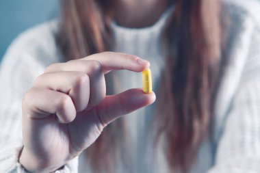 bir kapsül tutan genç kadın