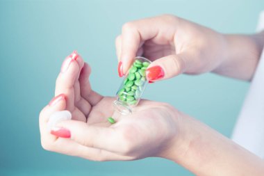 Elinde kapsüller tutan genç bir kadın.