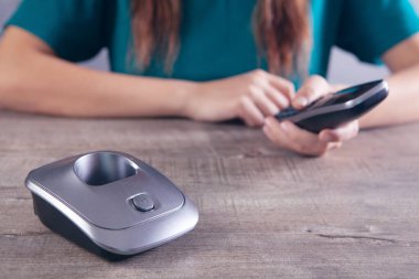 Kadın ev telefonundaki numarayı çeviriyor.