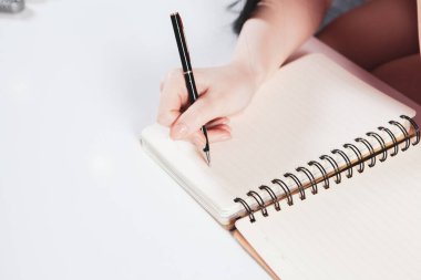 Genç kız not defterine notlar alır.