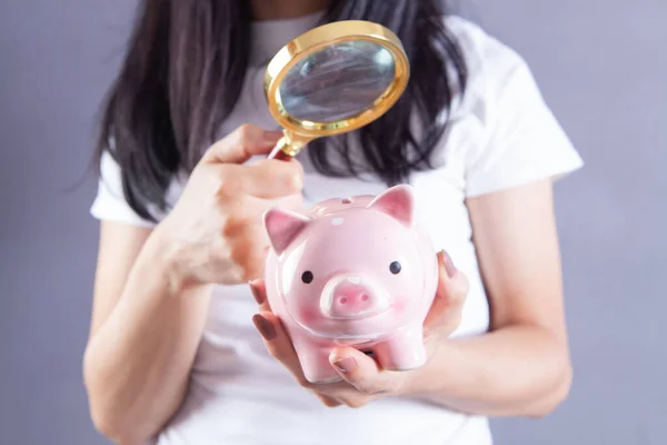 Woman Examines Piggy Bank Magnifying Glass — Stock Photo, Image