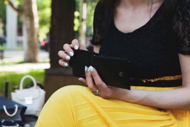 Kız parktaki cüzdandan para çekiyor.