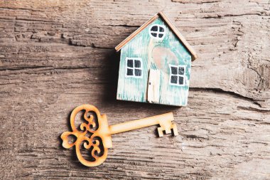Ahşap ev ve anahtarlar masanın üstünde.