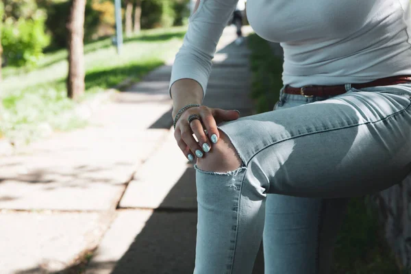 Kadının parkta diz ağrısı var.