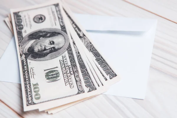 Dolar banknotları ve zarf masanın üstünde.