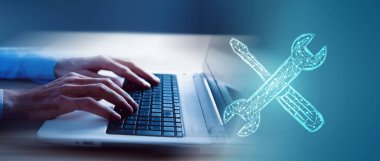 Resimli İngiliz anahtarı ve tornavida. Adam dizüstü bilgisayarla çalışıyor