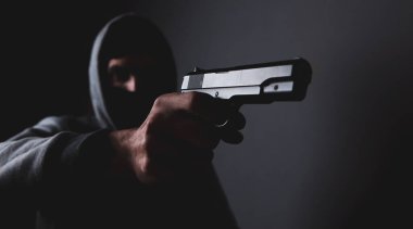 Maskeli adam silah taşıyor.