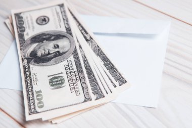 Dolar banknotları ve zarf masanın üstünde.