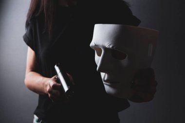 Maskeli kız silah taşıyor.