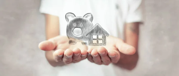 Man Holding House Icon Piggy Bank His Hand — стоковое фото