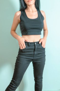 Kadın sütyen ve pantolon giymiş poz veriyor.