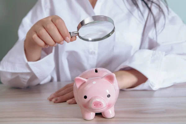 Woman Examines Piggy Bank Magnifying Glass — Stock Photo, Image