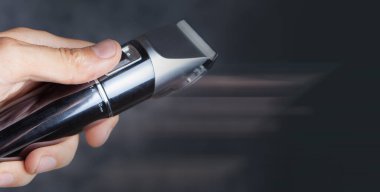 Gri arka planda el ele tıraş makinesi