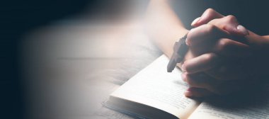 Kadın haç tutarak dua ediyor