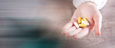 Elinde kapsüller tutan genç bir kadın.