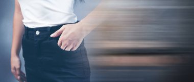 Kadın elini ön cebine koyar.