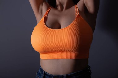 Kolsuz tişörtlü, kocaman göğüslü seksi kadın.