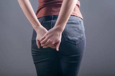 woman holding ass. hemorrhoids concept