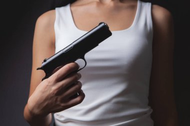 the girl is holding a gun in her hand.