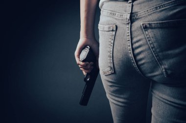 the girl is holding a gun in her hand.