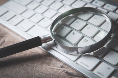 İnternet arama kavramı, büyüteç ve bilgisayar klavyesi