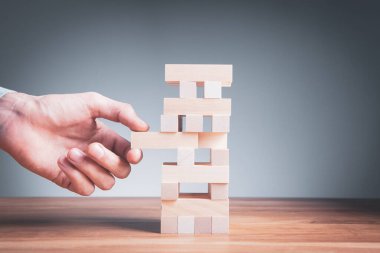 Ahşap küplerden bir yapı yapan bir iş adamının yakınlaşması. Bir iş konsepti inşa etmek.