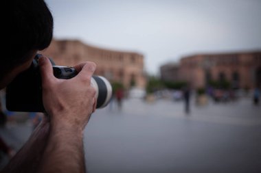 Fotoğraf makinesi tutan ve fotoğraf çeken bir fotoğrafçı